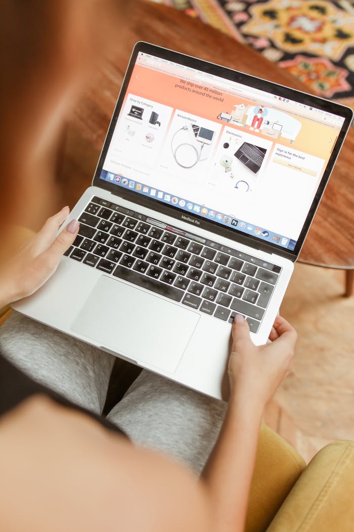 Focused woman browsing online store on laptop indoors, engaging in e-commerce activities.